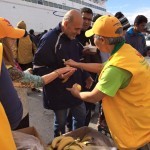 Distributing fruits and Arabic versions of Alternative Living flyers to refugees at the port in Mytilene - November 27, 2015