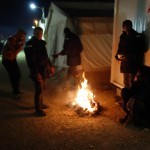 Refugees in Idomeni, Greece, trying to keep warm on a cold night - December 7, 2015