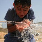 160591_Syrian Refugees in Gaza drinking water from farmers rebuilt well.jpg1